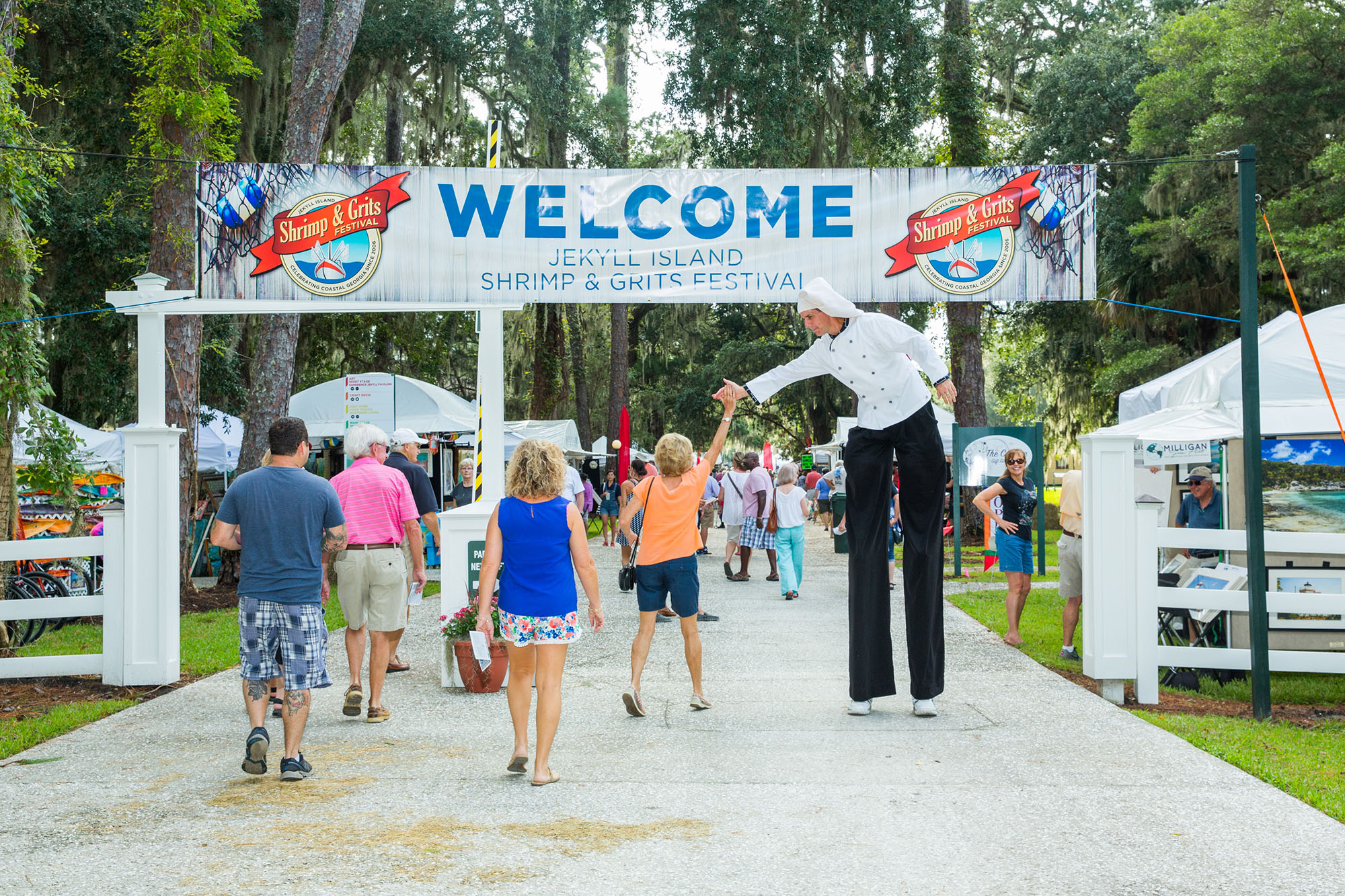man on stilts welcoming festival attendees