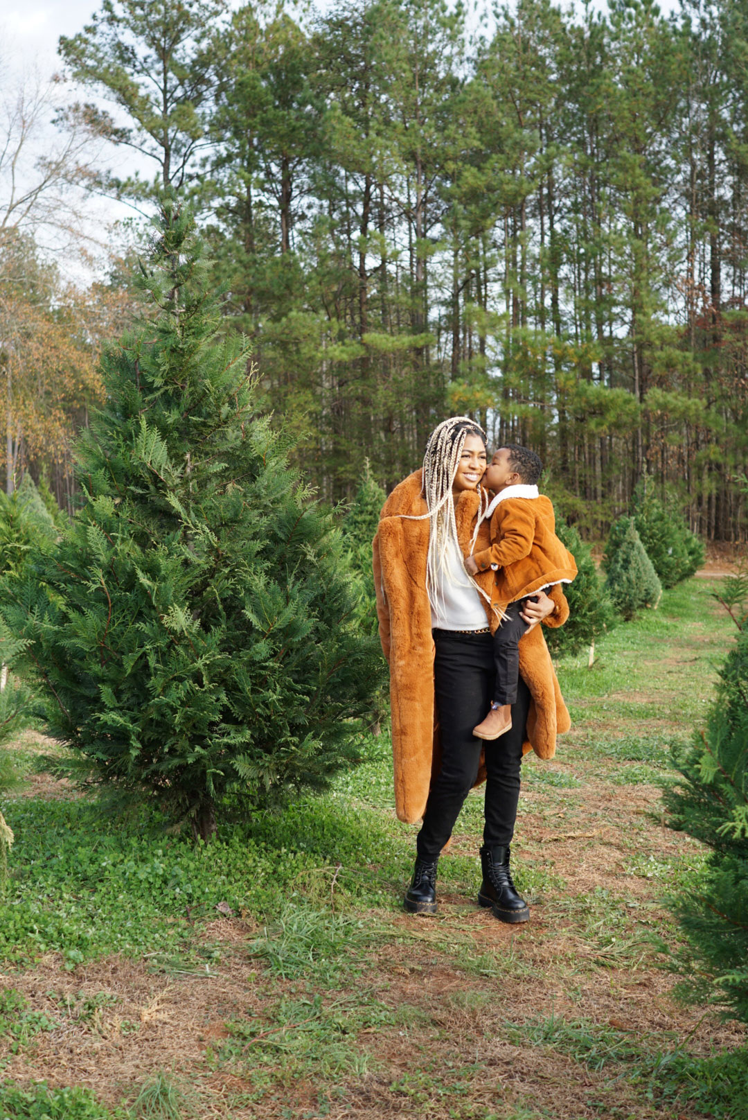 Woman and child in field of Christmas trees