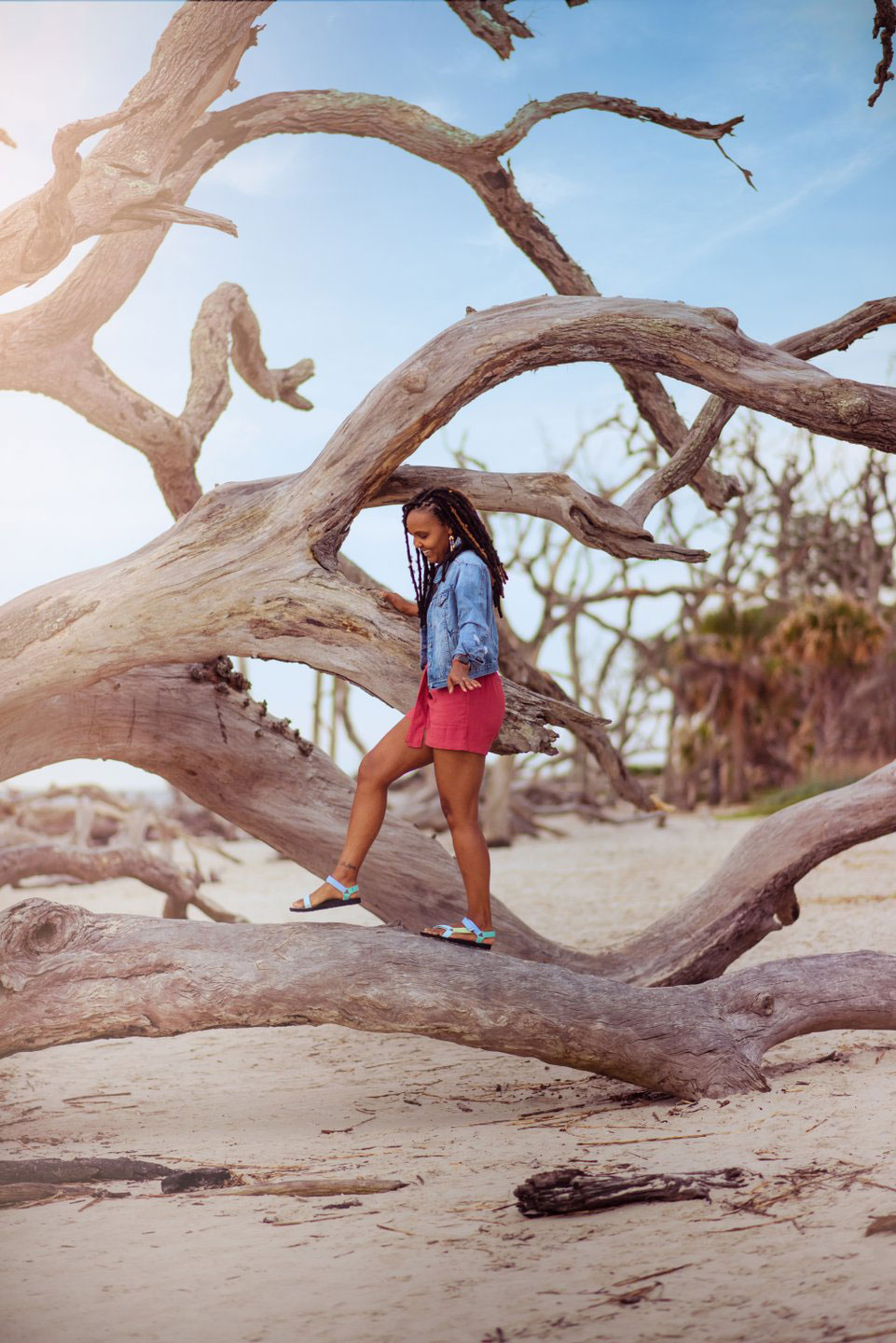 Woman walking on driftwood on Jekyll Island, Georgia