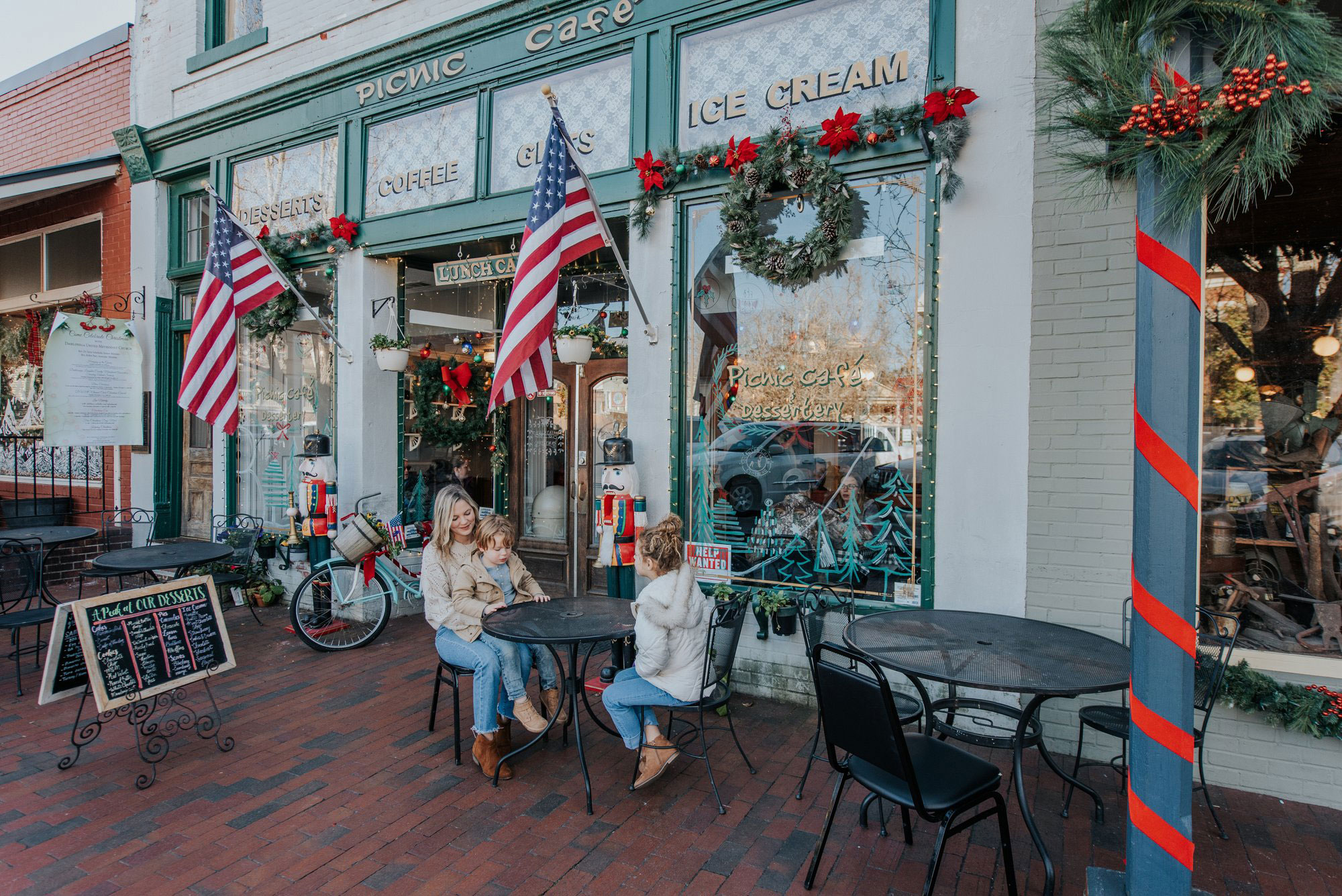 Family dining among holiday decorations in front of the Picnic Cafe in Dahlonega, Georgia