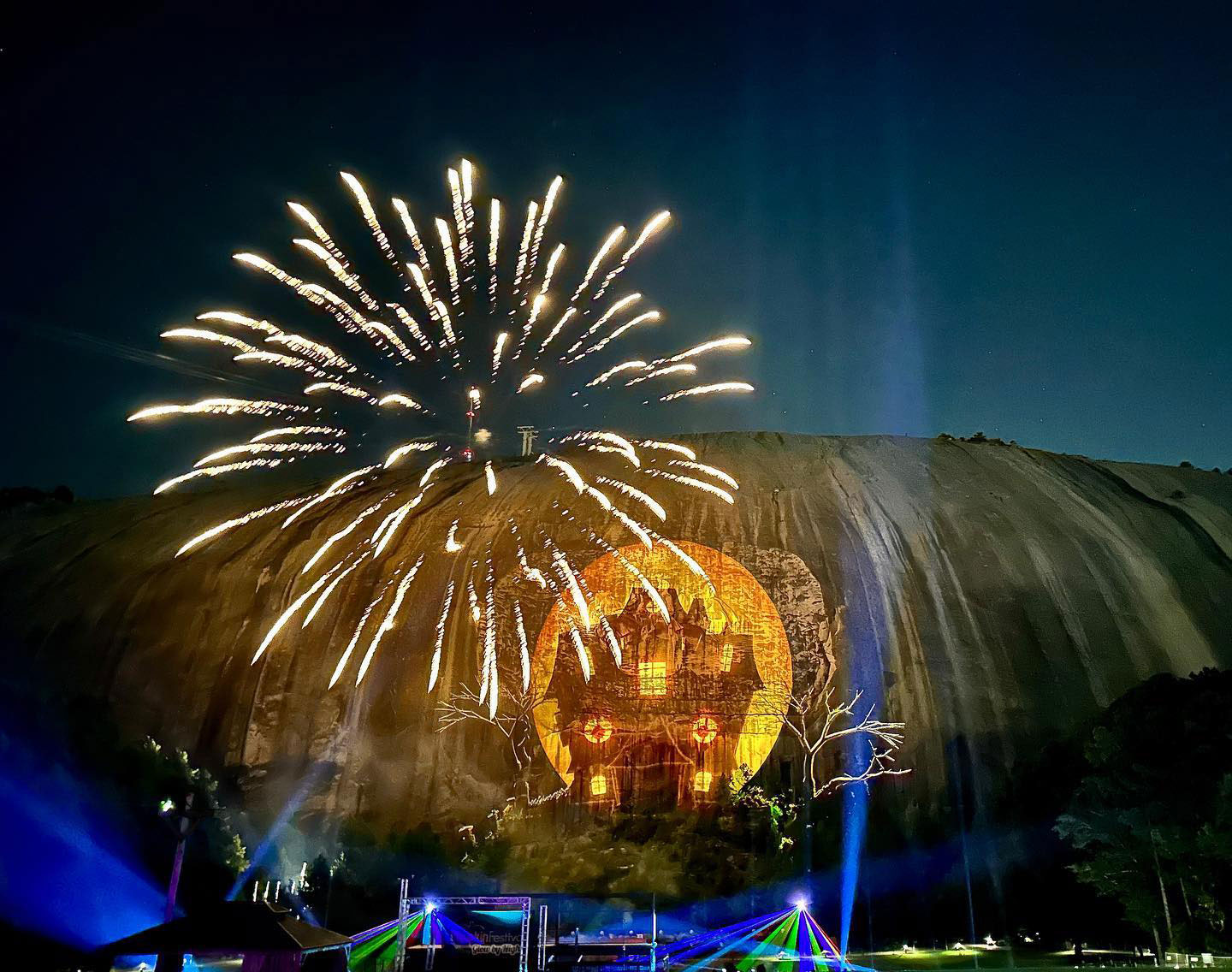 Fireworks and haunted house image projected onto Stone Mountain
