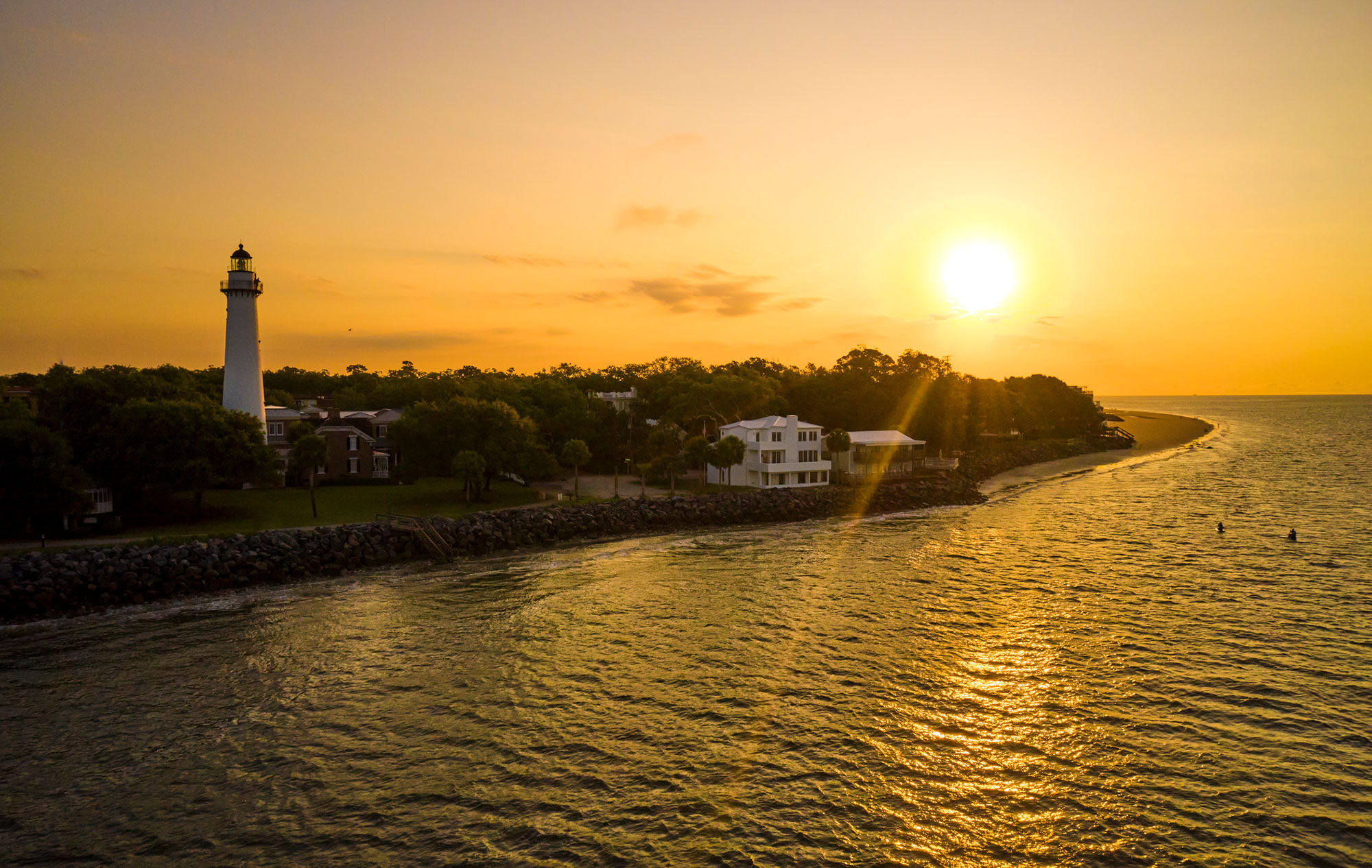 View of St. Simons Island Lighthouse from the water with the rising sun