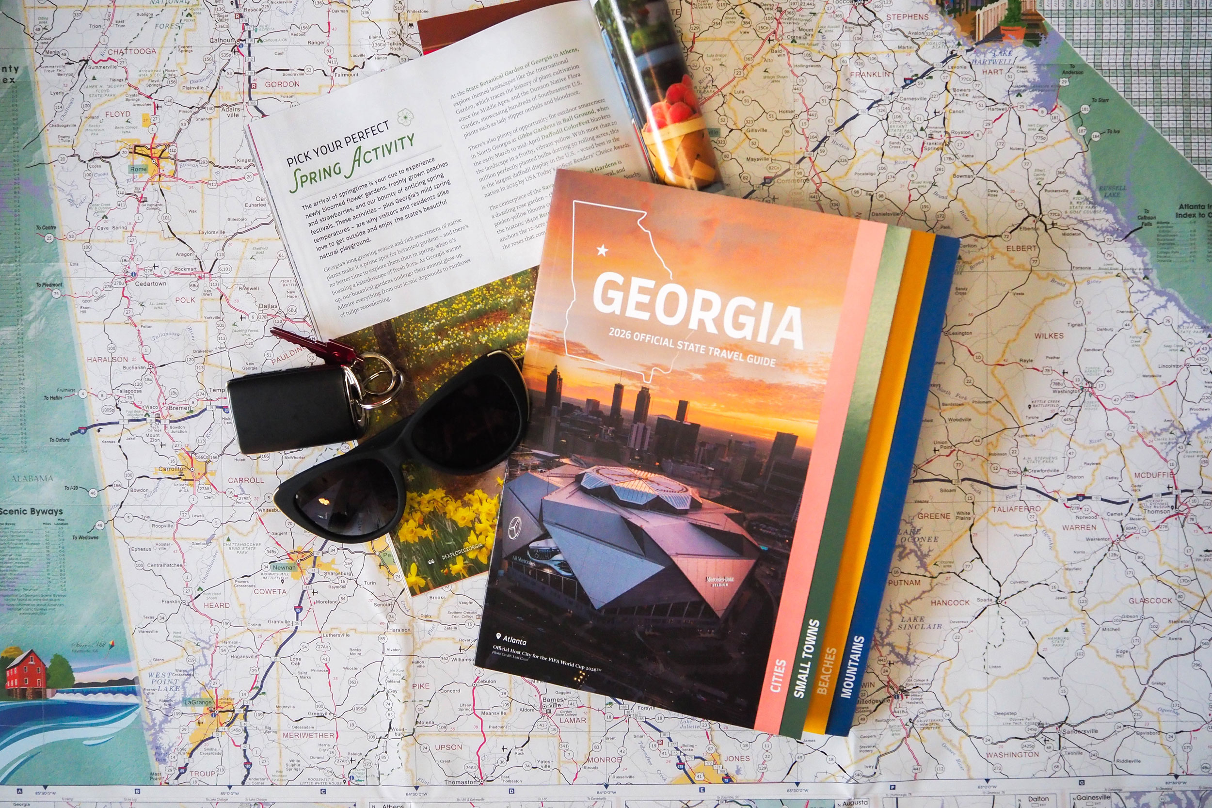 2026 Georgia Travel Guide cover with sunglasses and keys on a map background