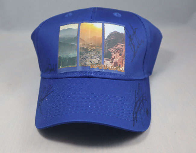 Royal blue baseball cap with three scenic photos and the word KAHNDAQ, plus autographs by Aldis Hodge, Noah Centineo, Quintessa Swindell, and Sarah Shahi