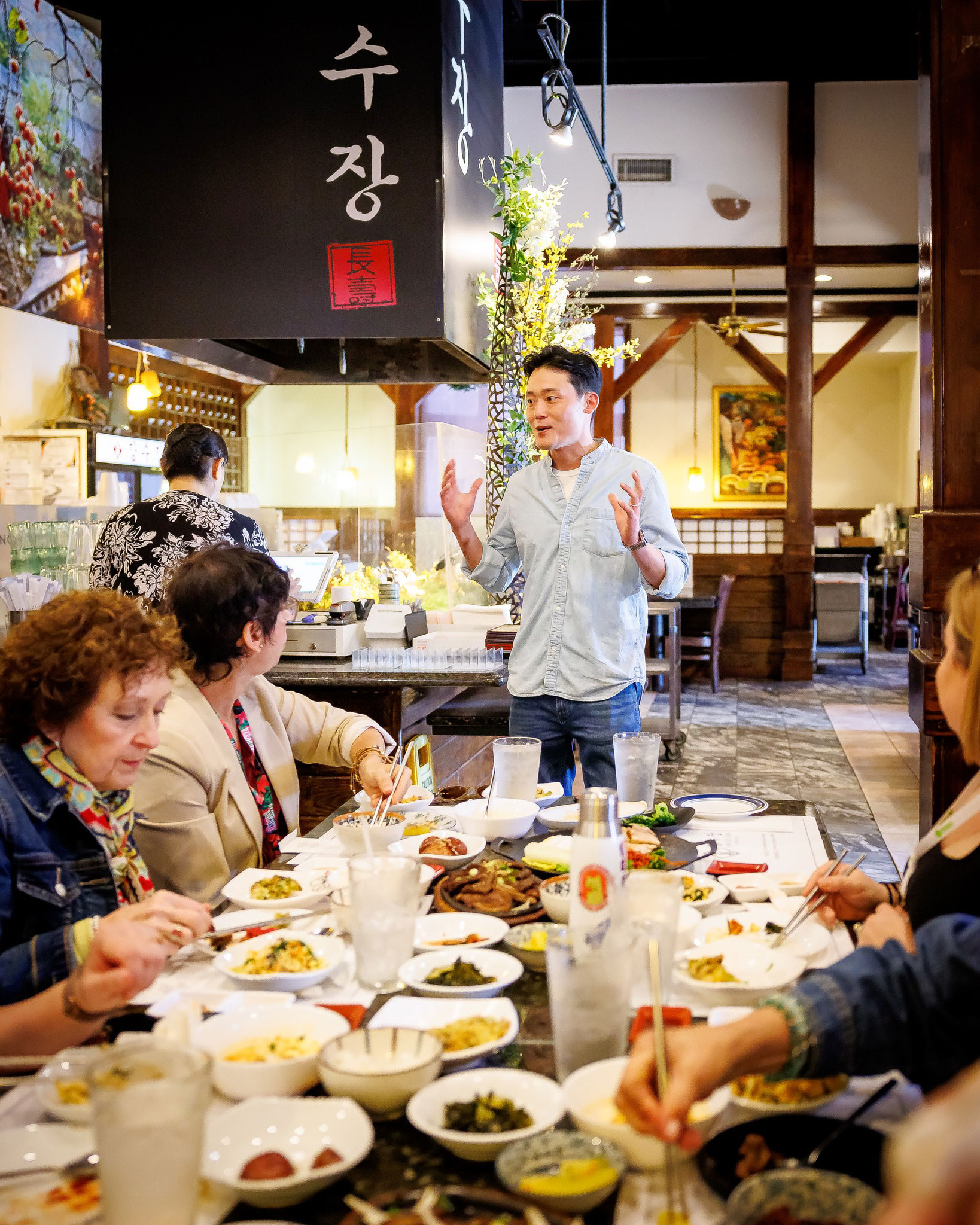 Tour guide and people dining on the Seoul of the South Food Tour in Duluth, Georgia