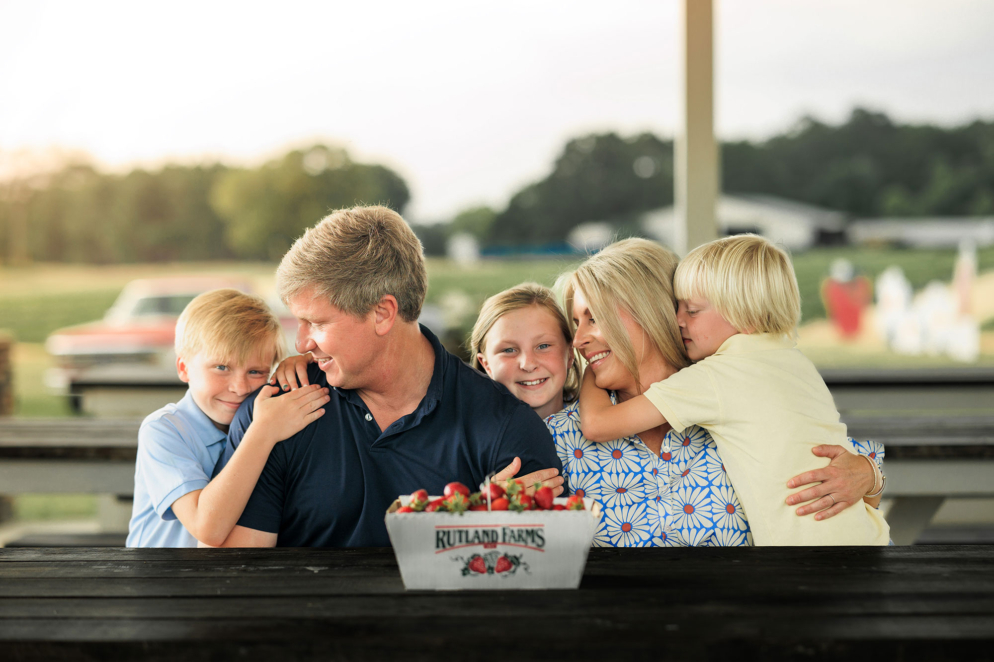 Family sitting at a table with a box of strawberries at Rutland Farms in Tifton, Georgia