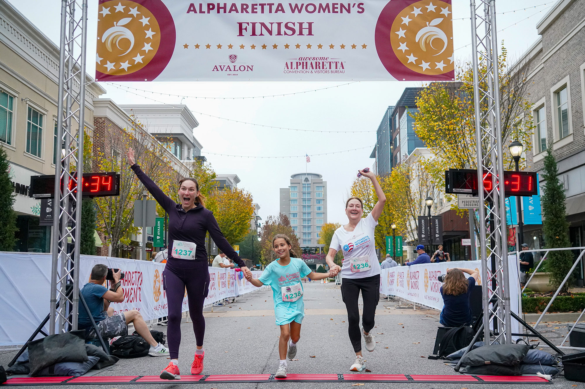 Three runners crossing the finish line at the Alpharetta Women's Half Marathon & 5K