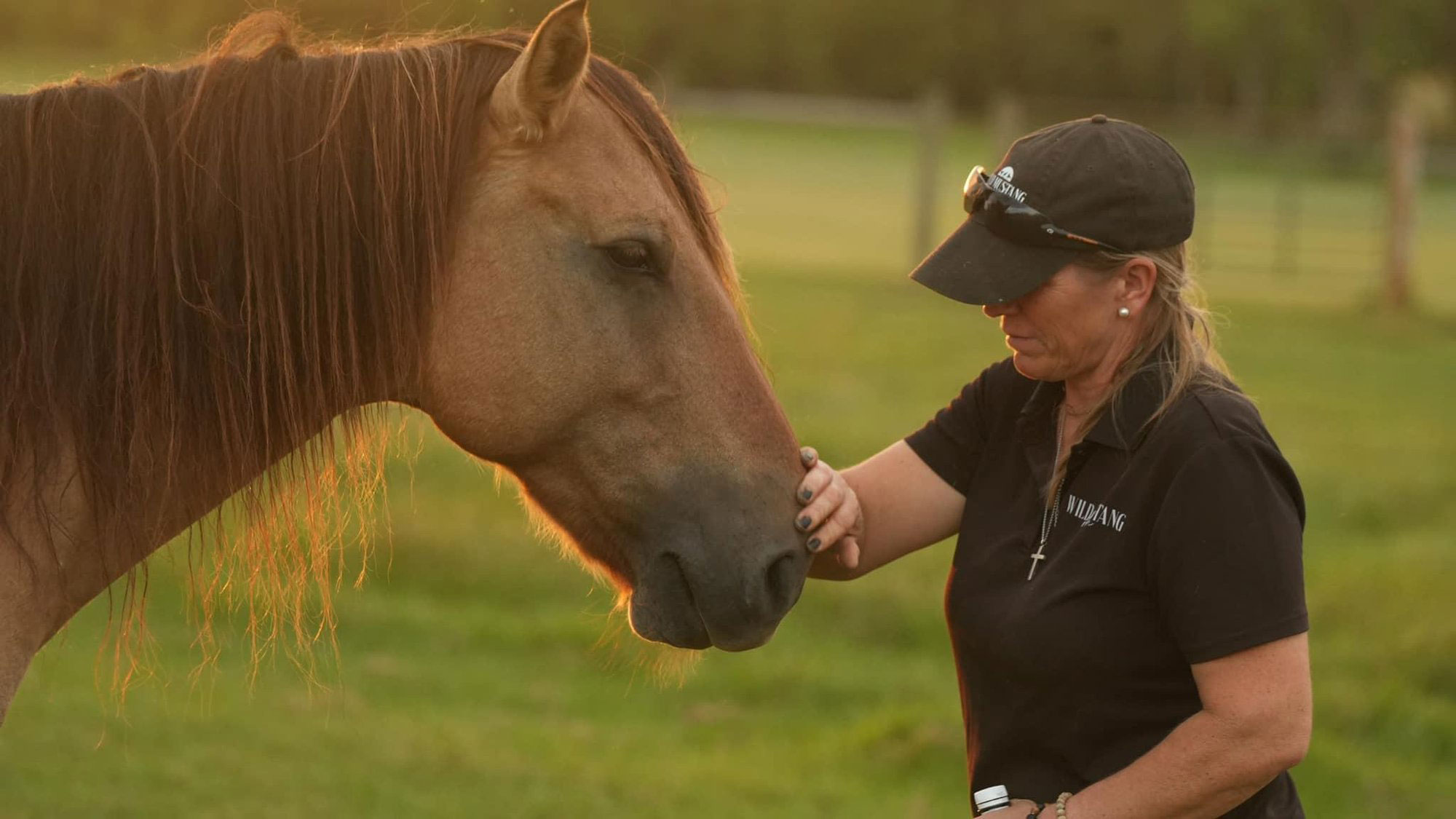 Woman petting a horse at Wild Mustang Ranch in Lyons, Georgia