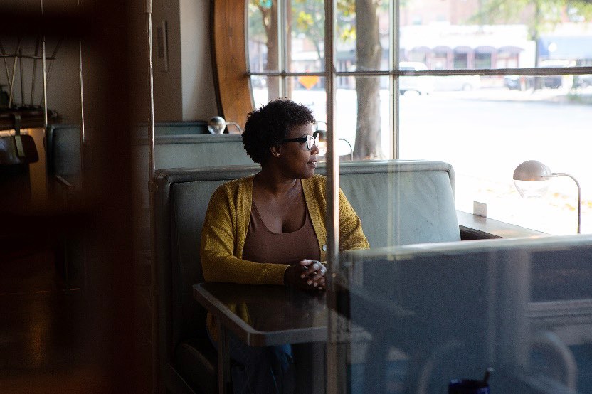 Chef Mashama Bailey sitting and looking out the window at The Grey in Savannah, Georgia