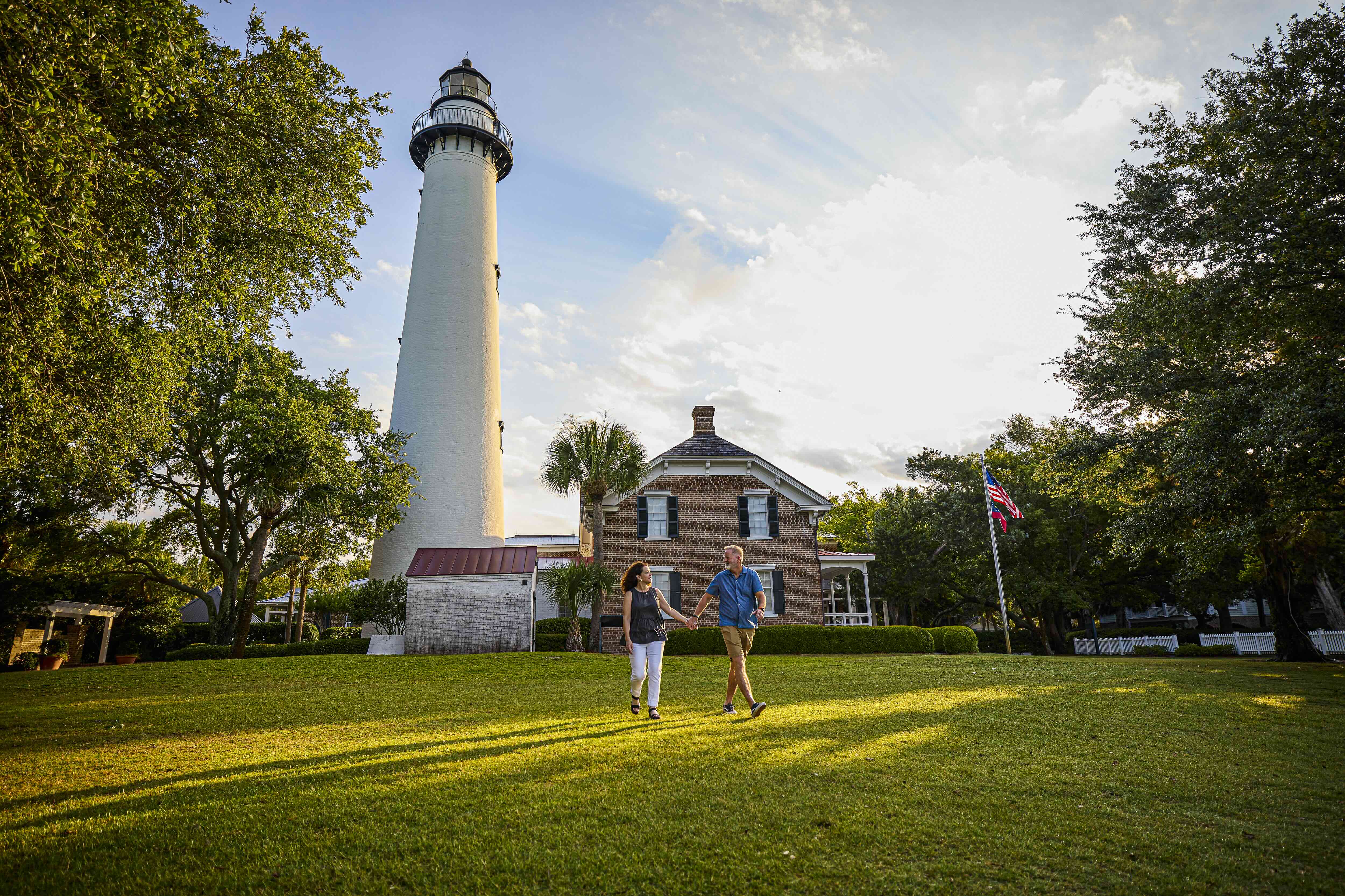 A couple walking in front of a lighthouse
