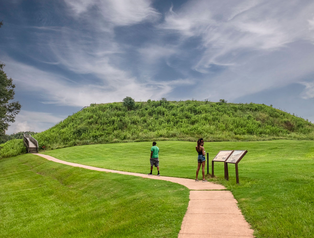 Grassy landscape with a paved path at Ocmulgee Mounds National Historical Park in Macon, Georgia.
