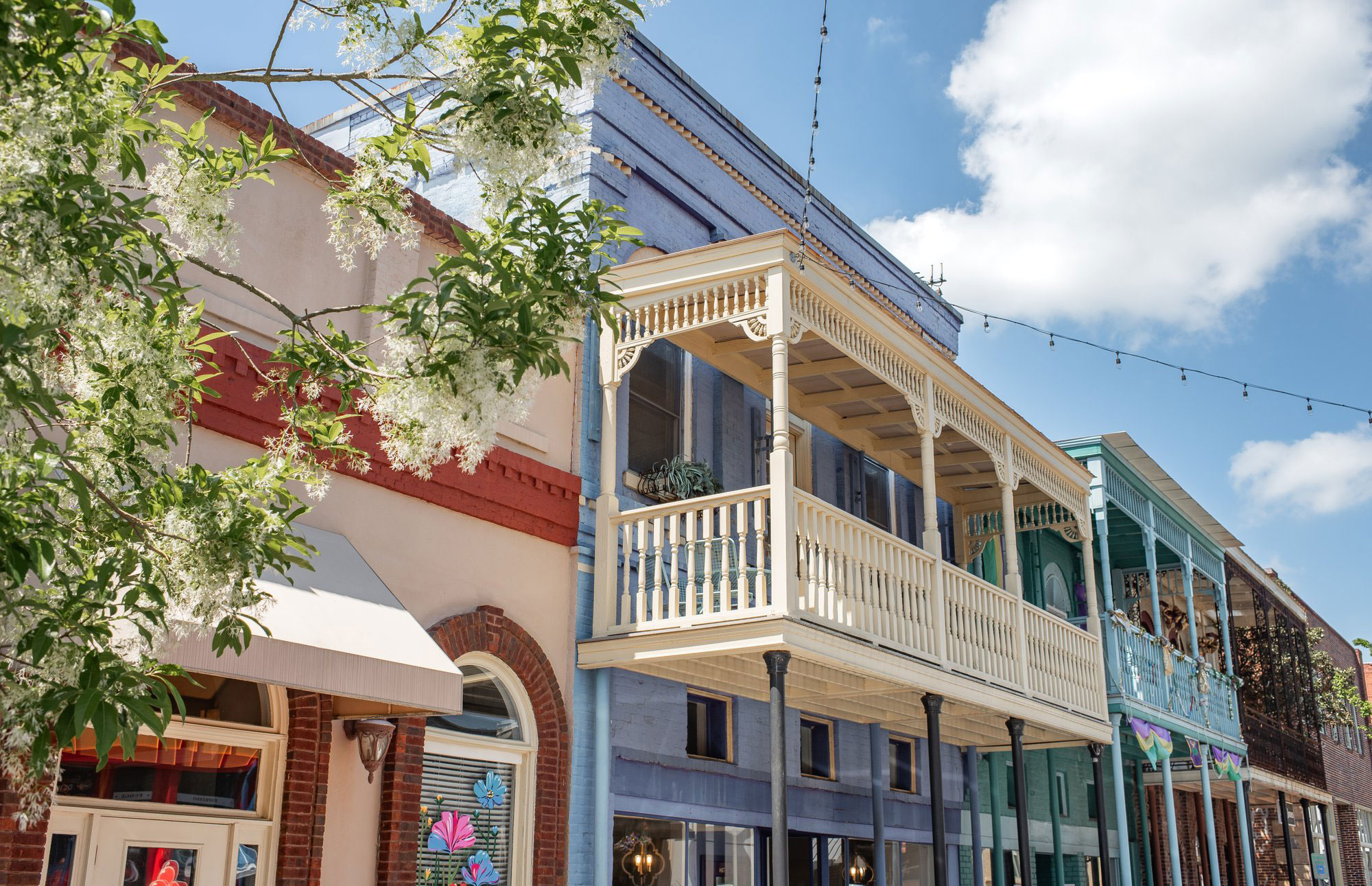 White covered balcony on a blue building in historic Olde Town Conyers
