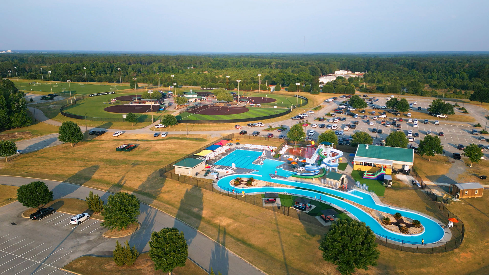 aerial view of pool, lazy river, water slides, parking lot and baseball fields at Southern Pines Water Park