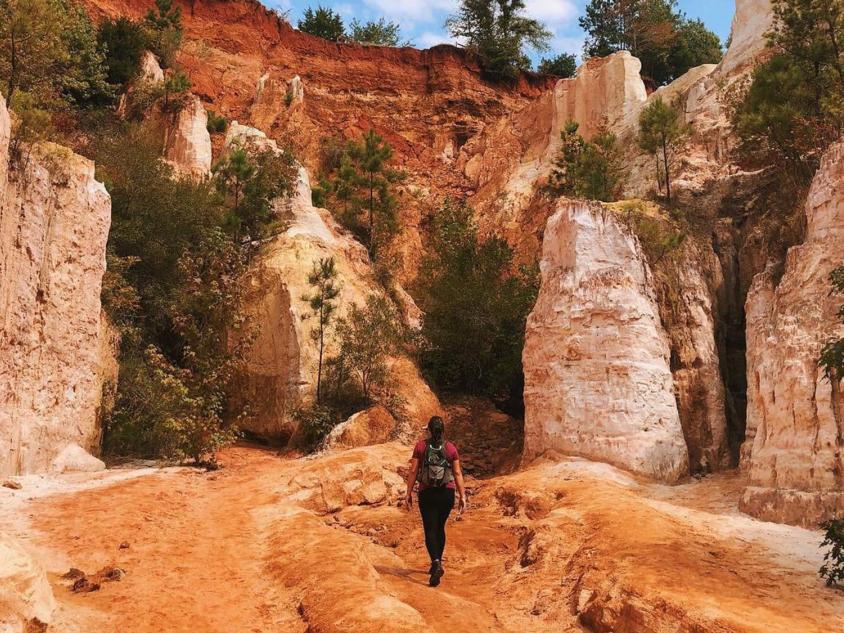 Hiker walking through a canyon surrounded by large rocks