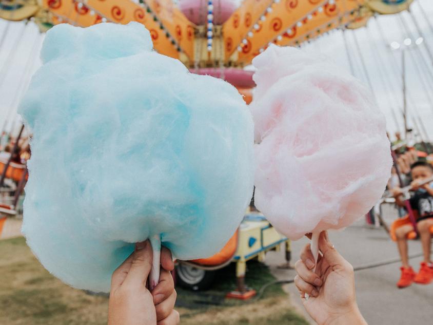 Two hands holding cotton candy at the North Georgia State Fair in Marietta, Georgia. Photo by @gcalebjones