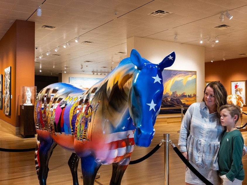 Family looking at a painted horse inside the Booth Western Art Museum in Cartersville, Georgia