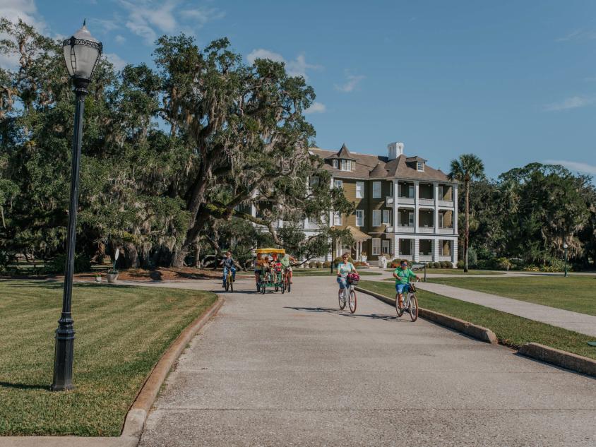 Family biking in front of Jekyll Island Club