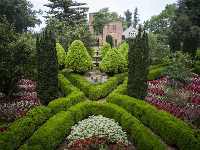 Lush and colorful gardens with a large resort in the background.