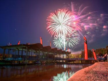 Colorful fireworks blast over the water at night