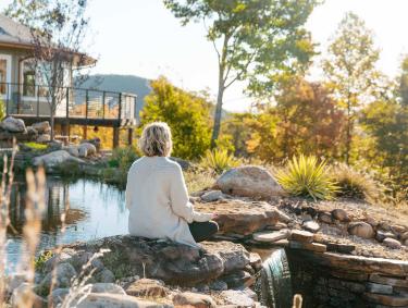 Woman meditating outside at Elohee in Sautee Nacoochee, Georgia
