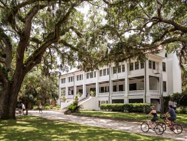 Cyclists riding in front of Greyfield Inn on Cumberland Island, Georgia