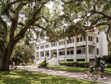 Cyclists riding in front of Greyfield Inn on Cumberland Island, Georgia