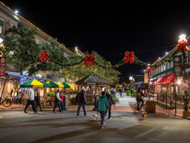 Shoppers stroll through a city market decorated with Christmas displays