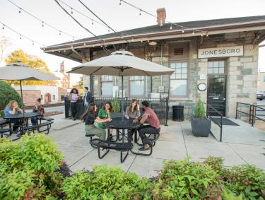 People sit enjoying themselves at outdoor tables at Clayton County Georgia's Visitors Center in Jonesboro