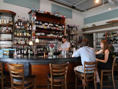 A bartender serving drinks to customers in Athens bar