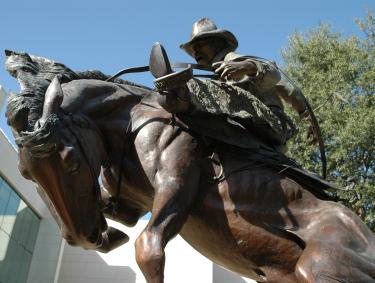 A large bronze statue of a cowboy riding a horse