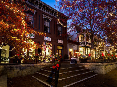 A small town street lit up with holiday lights.