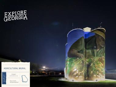 agricultural mural on silo at night w/ logo and location tag