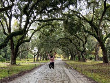 Girl jumping under the canopy of live oaks at Wormsloe State Historic Site in Savannah, Georgia. Photo by @serend1p1tyy