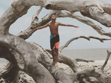 Boy on Driftwood Beach on Jekyll Island, Georgia. Photo by @qued3point14