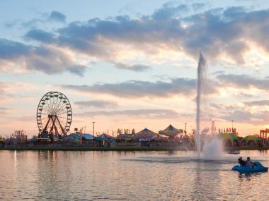 Water view of the Georgia National Fair at sunset with rides and carnival in the background