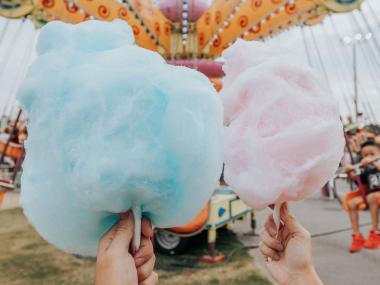 Two hands holding cotton candy at the North Georgia State Fair in Marietta, Georgia. Photo by @gcalebjones