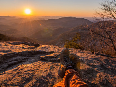 Hiker watching sunset on Preacher's Rock in Cleveland, Georgia. Photo by @afearfuljourney