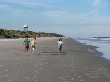 Kids running on Glory Beach on Jekyll Island, Georgia. Photo by @jekyll_island