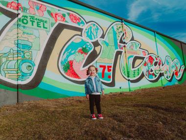 Young child standing in front of a mural in Tifton, Georgia