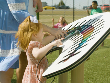 Child in a park playing a large xylophone in Dublin, Georgia