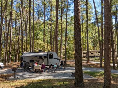 Family sitting at a picnic table near their RV