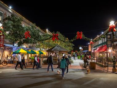 Shoppers stroll through a city market decorated with Christmas displays