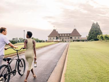 Couple walking a bike on a path toward Chateau Elan in Braselton, Georgia