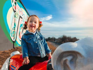 Child smiling in front of a mural in Tifton, Georgia