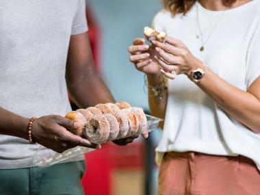 A couple holds a plate of apple-cider donuts