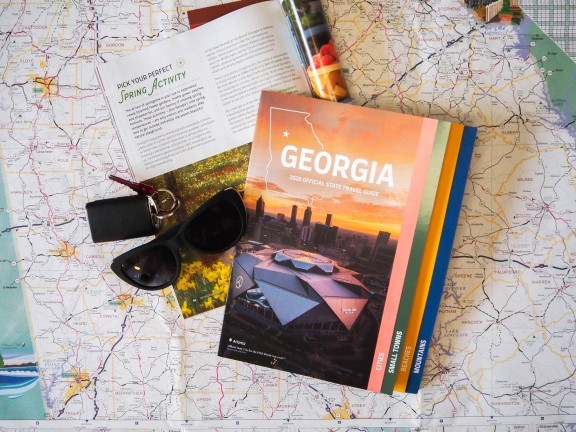 2026 Georgia Travel Guide with sunglasses and keys on a map background