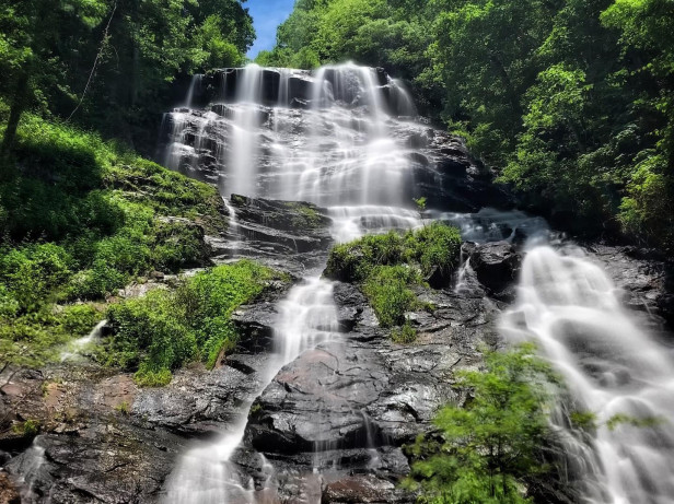 A waterfall rushes down moss-covered rocks.