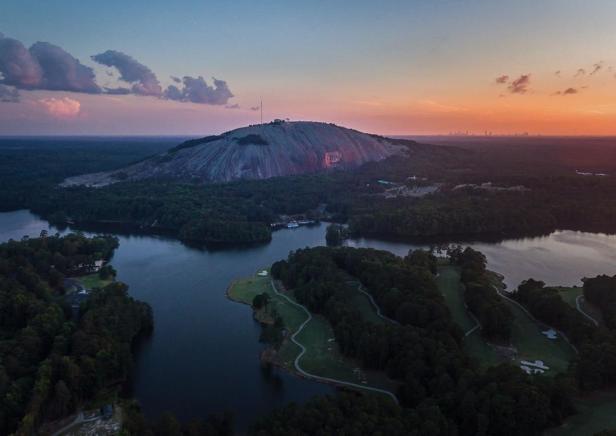 Aerial view of a mountain park with a sunset in the distance.