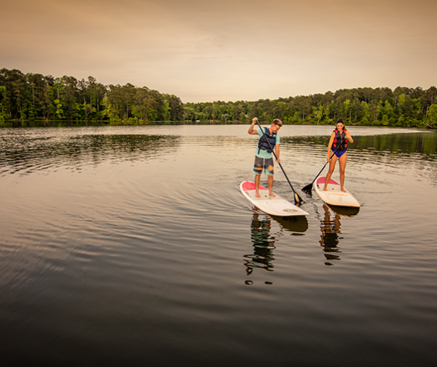 2 kids paddleboard on the lake