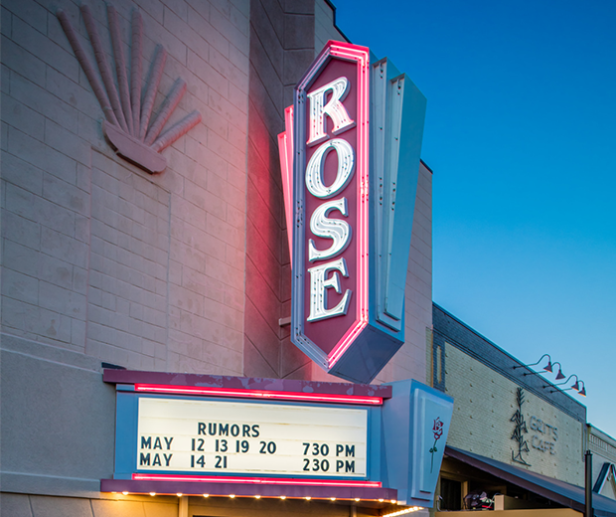 Rose Theater sign light up in neon at night